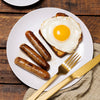 Breakfast Sausages and a fried egg on top of a toast in a plate.