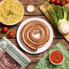 Sausage pinwheel with a dipping sauce and pasta on the side.