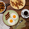 Breakfast Sausage in a plate with egg. A cup of Coffee, extra plate of sausages and Potato skillet on the side.