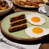 Breakfast Sausage in a plate with egg. A cup of Coffee, extra plate of sausages and Potato skillet on the side.