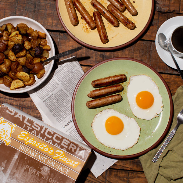 Breakfast Sausage in a plate with egg. A cup of Coffee, extra plate of sausages, box of the Sausage and Potato skillet on the side.