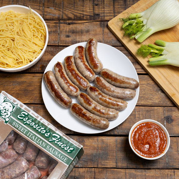 Cooked Sweet Italian Sausage with pasta and a dipping sauce in a table.